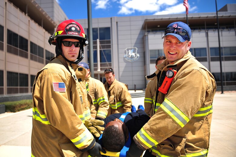 SCHRIEVER AIR FORCE BASE, Colo.-Jon Rinesmith (left), 50th Civil Engineer Squadron lead firefighter, and Henry Stratton (right), 50th CES firefighter, carry a victim out of the Building 210 following simulated active shooter incident as part of the Front Range Expeditionary Exercise 19-01 at Schriever Air Force Base, Colorado, April 25, 2019. The exercise brought various first response agencies together in a coordinated effort to test their ability to work together as one team at their respective installations and in support of one another. (U.S. Air Force photo by Dennis Rogers)