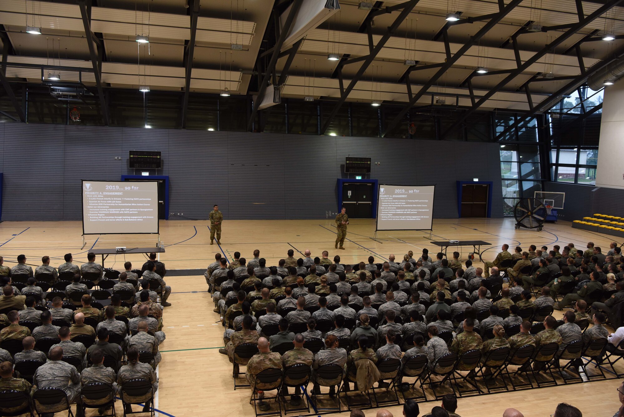 U.S. Air Force Brig. Gen. Mark R. August, 86th Airlift Wing commander, and Chief Master Sgt. Ernesto Rendon, 86th AW command chief, speak to a group of Airmen at an all-call on Ramstein Air Base, Germany, April, 26, 2019. During the all-call the 86th AW leadership focused on the wing’s mission capabilities and readiness.