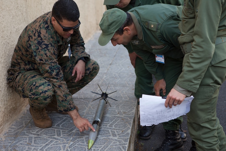 A U.S. Marine with Special Purpose Marine Air-Ground Task Force-Crisis Response-Africa 19.2, Marine Forces Europe and Africa, discusses explosive ordnance identification procedures with a member of the Moroccan Royal Armed Forces during Humanitarian Mine Action training at Unite de Secours et Sauvetage’s Base, Kenitra, Morocco, April 22, 2019. The Moroccan soldiers trained alongside the U.S. Marines in order to identify and properly dispose of explosive ordnance. SPMAGTF-CR-AF is deployed to conduct crisis-response and theater-security operations in Africa and promote regional stability by conducting military-military training exercises throughout Europe and Africa. (U.S. Marine Corps photo by Capt. Clay Groover)