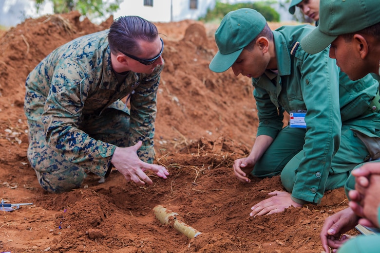 A U.S. Marine with Special Purpose Marine Air-Ground Task Force-Crisis Response-Africa 19.2, Marine Forces Europe and Africa, discusses explosive ordnance identification procedures with a member of the Moroccan Royal Armed Forces during Humanitarian Mine Action training at Unite de Secours et Sauvetage’s Base, Kenitra, Morocco, April 22, 2019. The Moroccan soldiers trained alongside the U.S. Marines in order to identify and properly dispose of explosive ordnance. SPMAGTF-CR-AF is deployed to conduct crisis-response and theater-security operations in Africa and promote regional stability by conducting military-military training exercises throughout Europe and Africa. (U.S. Marine Corps photo by Capt. Clay Groover)