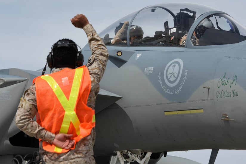 A service member marshals an aircraft.