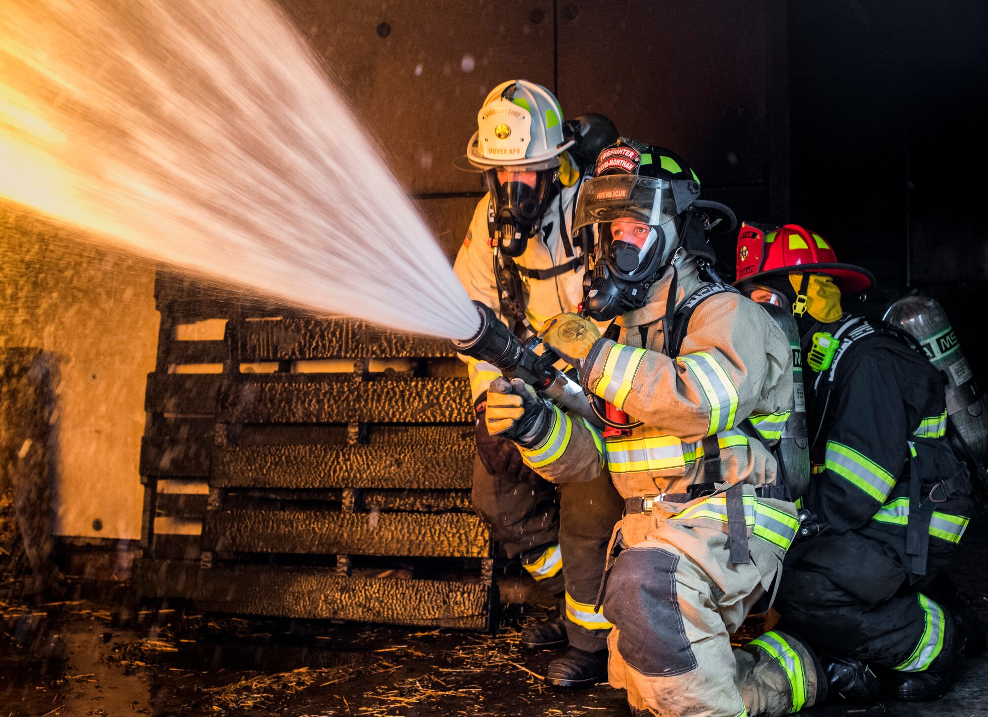 Senior Airman Daniel Kolk, 436th Civil Engineer Squadron driver operator, extinguishes flames in a controlled exercise at the structural burn training facility April 26, 2019, at Dover Air Force Base, Del. The firefighters train in structural live burns, aircraft burn exercises and vehicle extrication on a car crash victim. (U.S. Air Force photo by Senior Airman Christopher Quail)