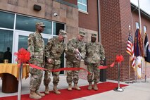 Center, Col. Eric D. Little, 1st Space Brigade commander, and Lt. Gen. James H. Dickinson, U.S. Army Space and Missile Defense Command/Army Forces Strategic Command commanding general, cut the ribbon during a ceremony April 11 signifying the official transfer of the 1st Space Brigade headquarters to Fort Carson. From left, Command Sgt. Maj. Robert Bell, 1st Space Brigade command sergeant major; Little; Dickinson; and Command Sgt. Maj. Finis A. Dodson, USASMDC/ARSTRAT command sergeant major. (U.S. Army Photo by Dottie White)