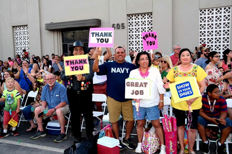 Fiesta Flambeau parade attendees greet the Air Force Reserve Command’s 433rd Airlift Wing and 960th Cyberspace Wing walkers and float, as it made its way through downtown San Antonio during the Flambeau Parade, April 27, 2019.