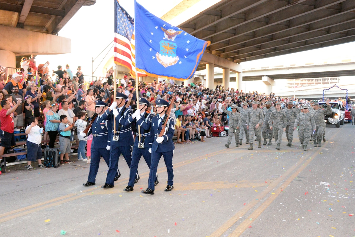 The 433rd Airlift Wing's Honor Guard leads the 433rd Airlift Wing and 960th Cyberspace Wing walkers and float on Broadway Street in downtown San Antonio during the 71st annual Fiesta Flambeau Parade, April 27, 2019.