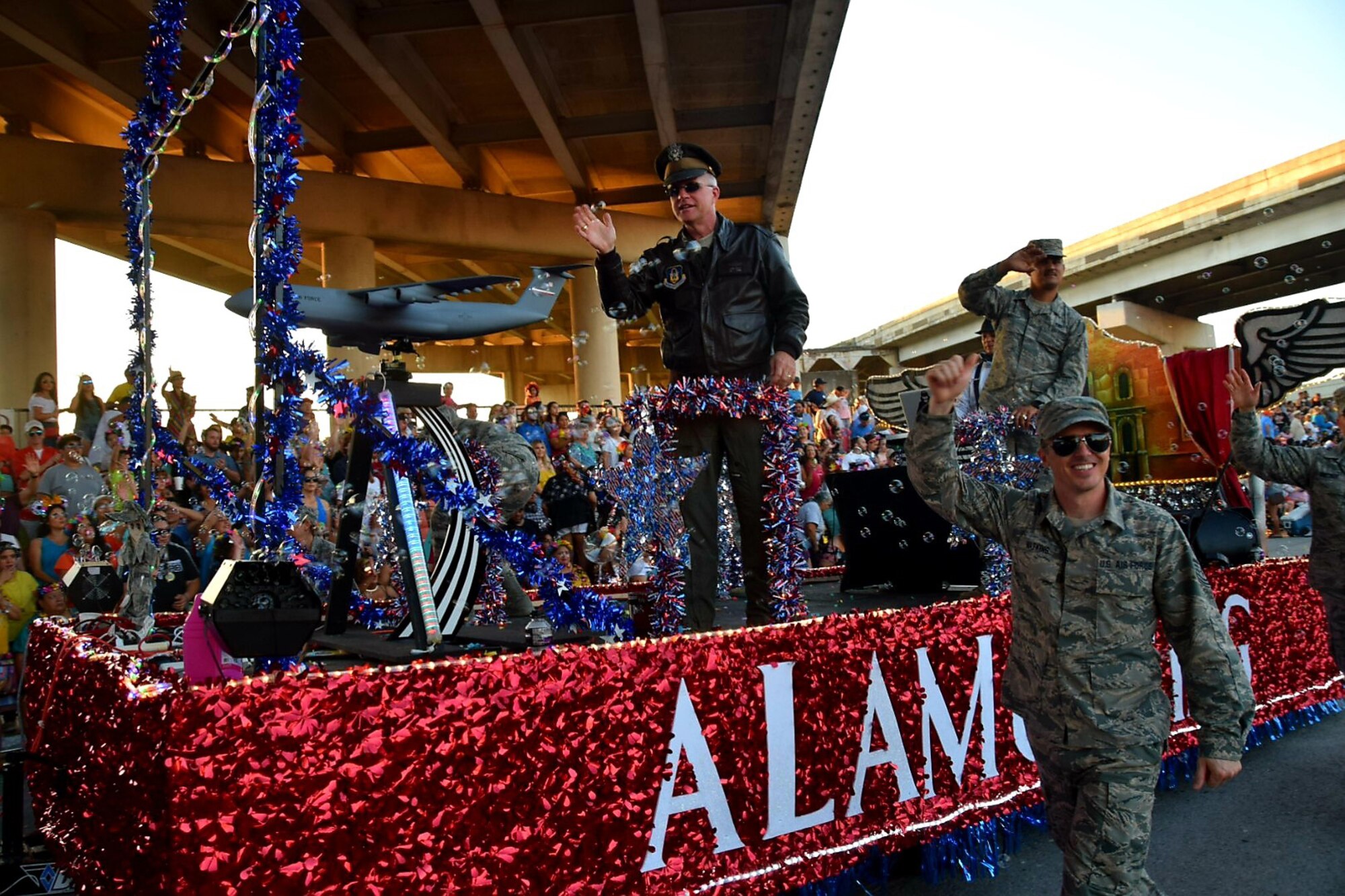 Col. David A. Scott, 433rd Airlift Wing vice commander, waves to the crowd during the 71st annual Fiesta Flambeau Parade, April 27, 2019.