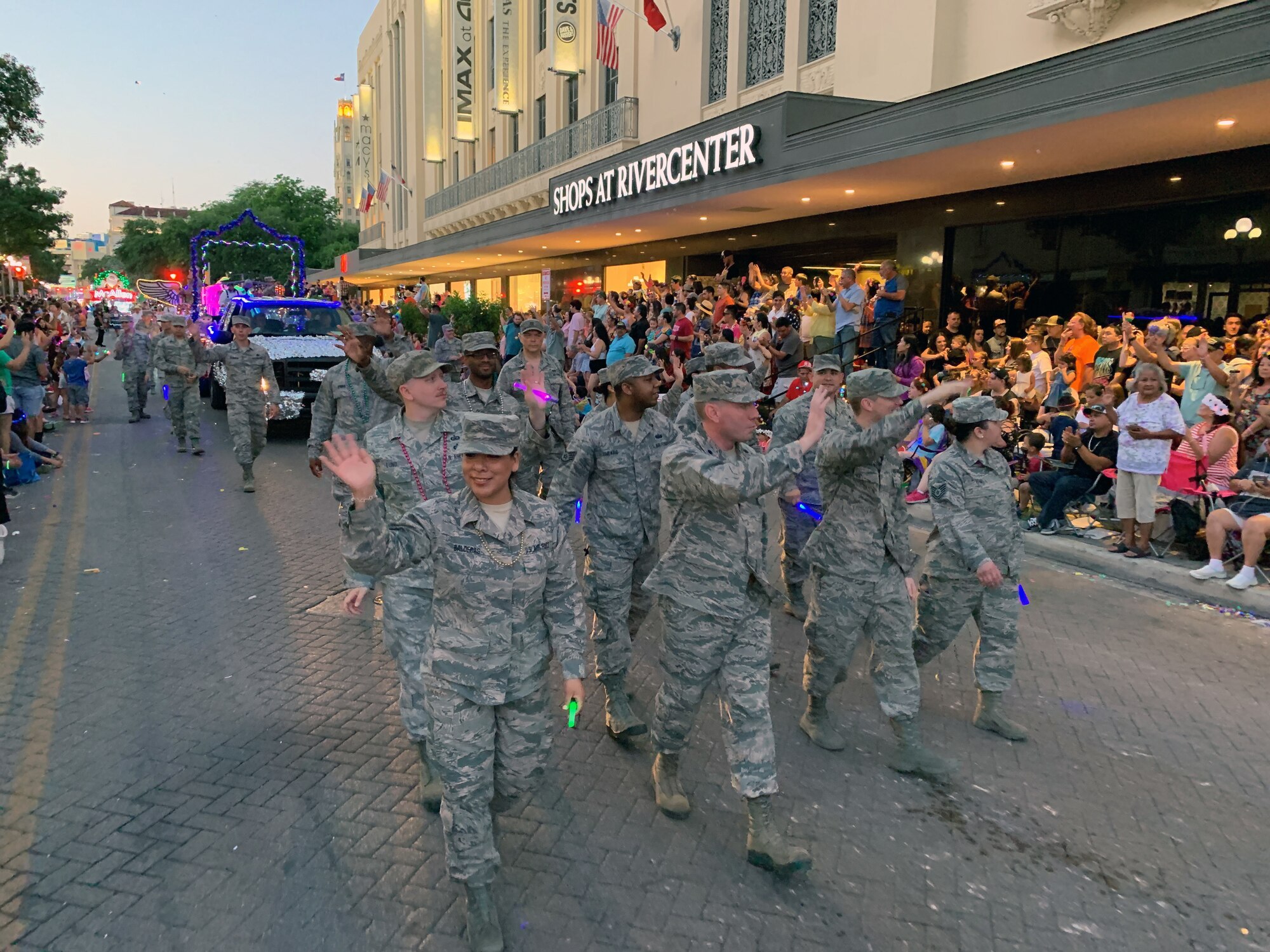 Reserve Citizen Airmen from the 433rd Airlift Wing and 960th Cyberspace Wing wave to parade goers on Broadway St. in downtown San Antonio during the 71st annual Fiesta Flambeau Parade, April 27, 2019.