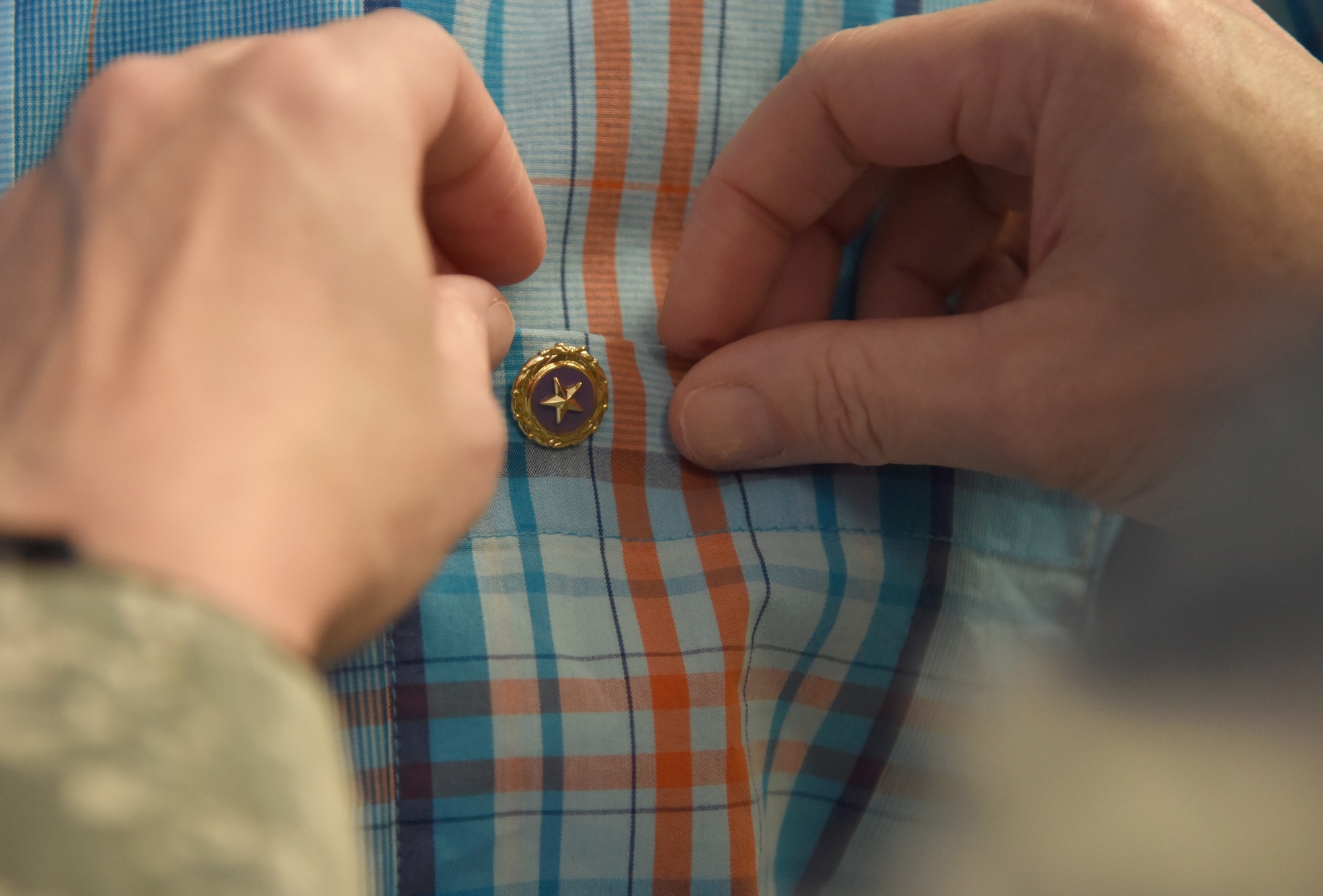 U.S. Air Force Col. Debra Lovette, 81st Training Wing commander, pins a Gold Star Family Member lapel pin on the shirt of Ashton Belcher, brother of Maj. Robert Belcher, inside the Visitors Center at Keesler Air Force Base, Mississippi, April 26, 2019. Robert was a F-4 pilot who served during the Vietnam War and was placed in POW/MIA status following his disappearance while on a mission to mark targets in 1969. As a surviving brother of a POW/MIA service member, Ashton is allowed to obtain an ID card for recognition and installation access so that he can attend events and access Airman & Family Readiness Center referral services. (U.S. Air Force photo by Kemberly Groue)