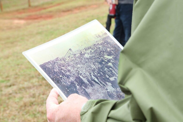 A Marine holds a photograph of prisoners of war at Camp Sumter, commonly known as the Andersonville Prison, during a recent tour.