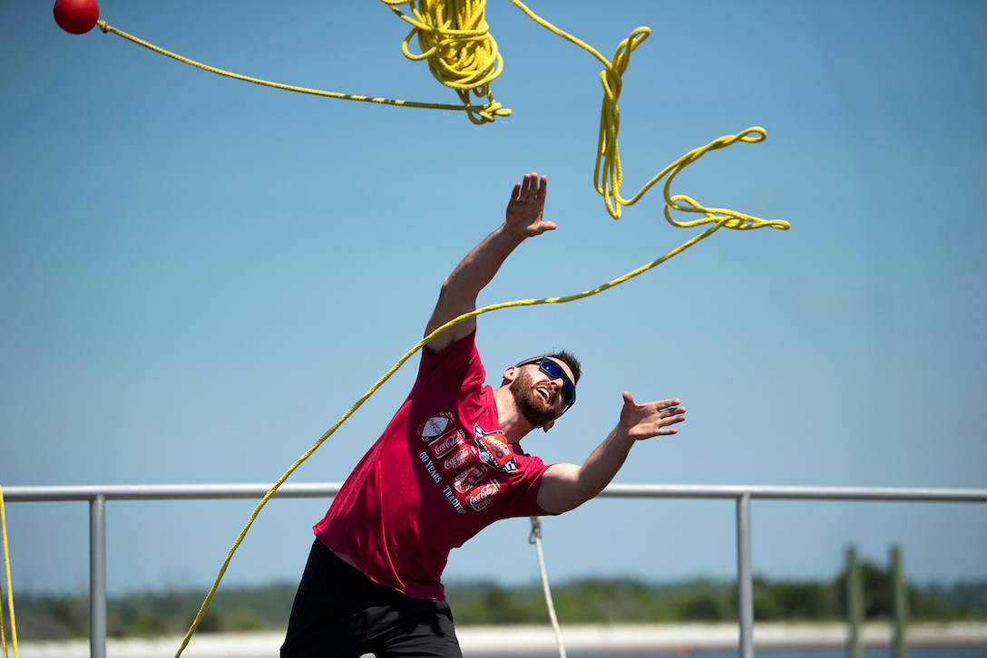 A man throws a yellow rope.