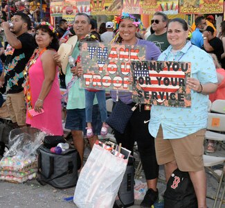 Fiesta Flambeau parade attendees greet the Air Force Reserve Command’s 433rd Airlift Wing and 960th Cyberspace Wing, as they made their way through downtown San Antonio during the Flambeau Parade April 27. San Antonio is known as "Military City U.S.A.," with 750,000 spectators lining the streets showing their appreciation by giving high fives to the Reserve Citizen Airmen walking alongside the float. Many taking photos with the Reservists, and giving an occasional hug.