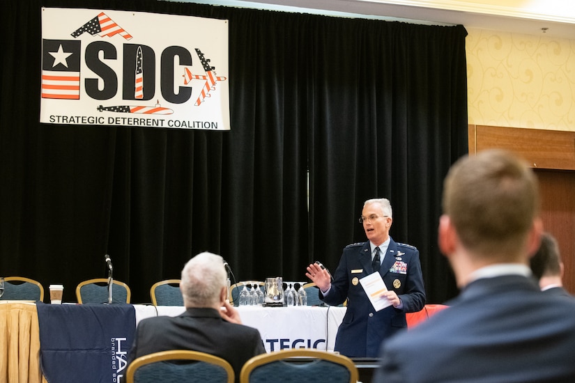 A military general speaks before an audience.