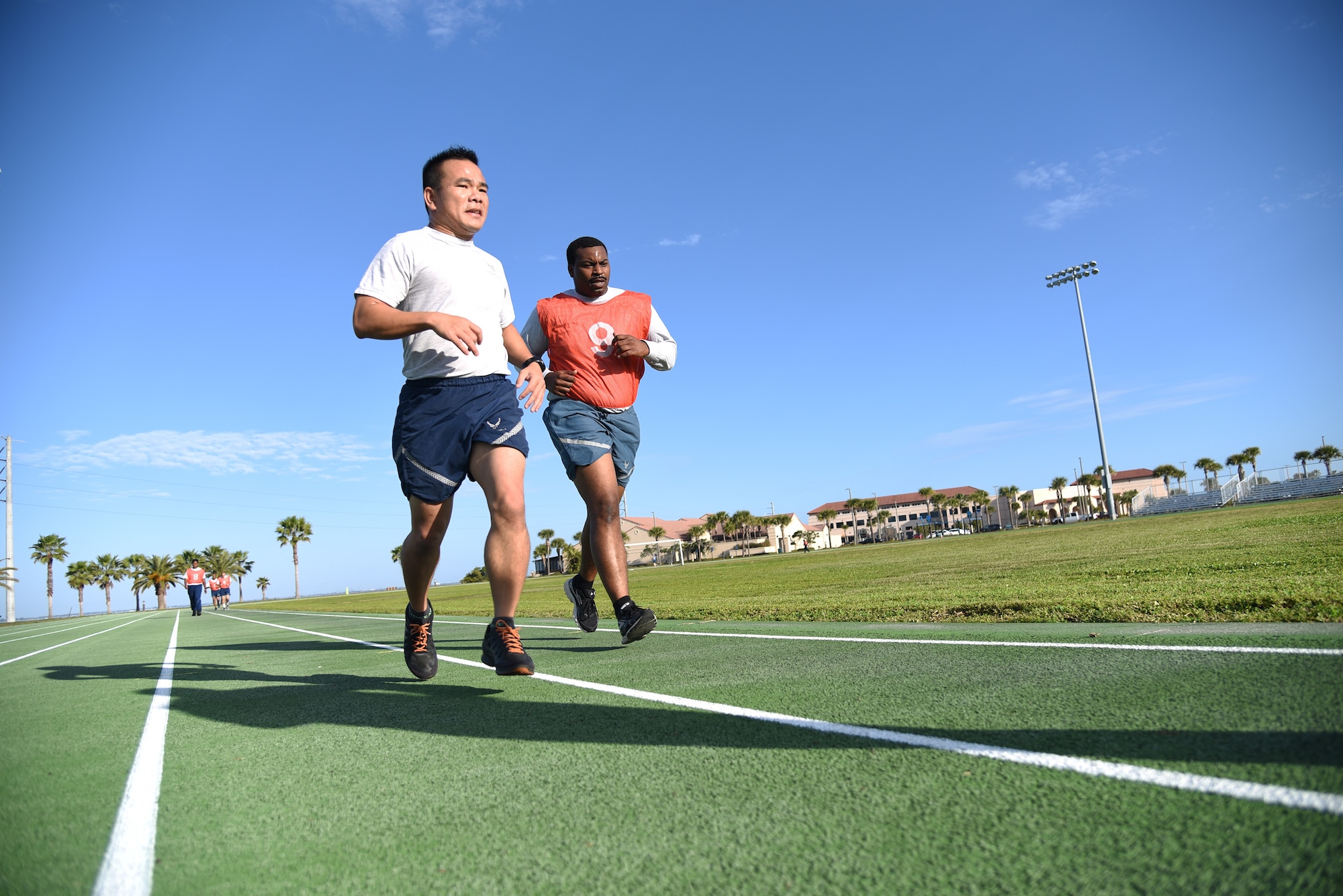 Lt. Col. Asan Bui runs alongside Senior Airman Kevin Frazier to cheer him on during a physical training test at Patrick Air Force Base, Florida, on Jan. 13, 2019. Both men are a part of the 920th Rescue Wing’s Communications Flight, with Bui serving as the commander. Frazier expressed his gratitude and said the support helped him beat his previous record.  (U.S. Air Force photo by Senior Airman Brandon Kalloo Sanes)