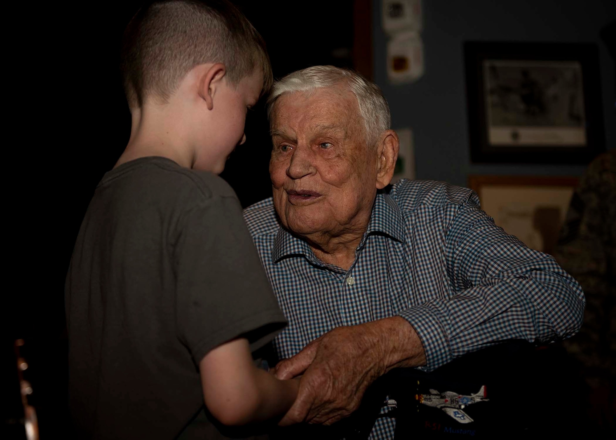 A young boy shakes hands with a Army Air Corps retiree.