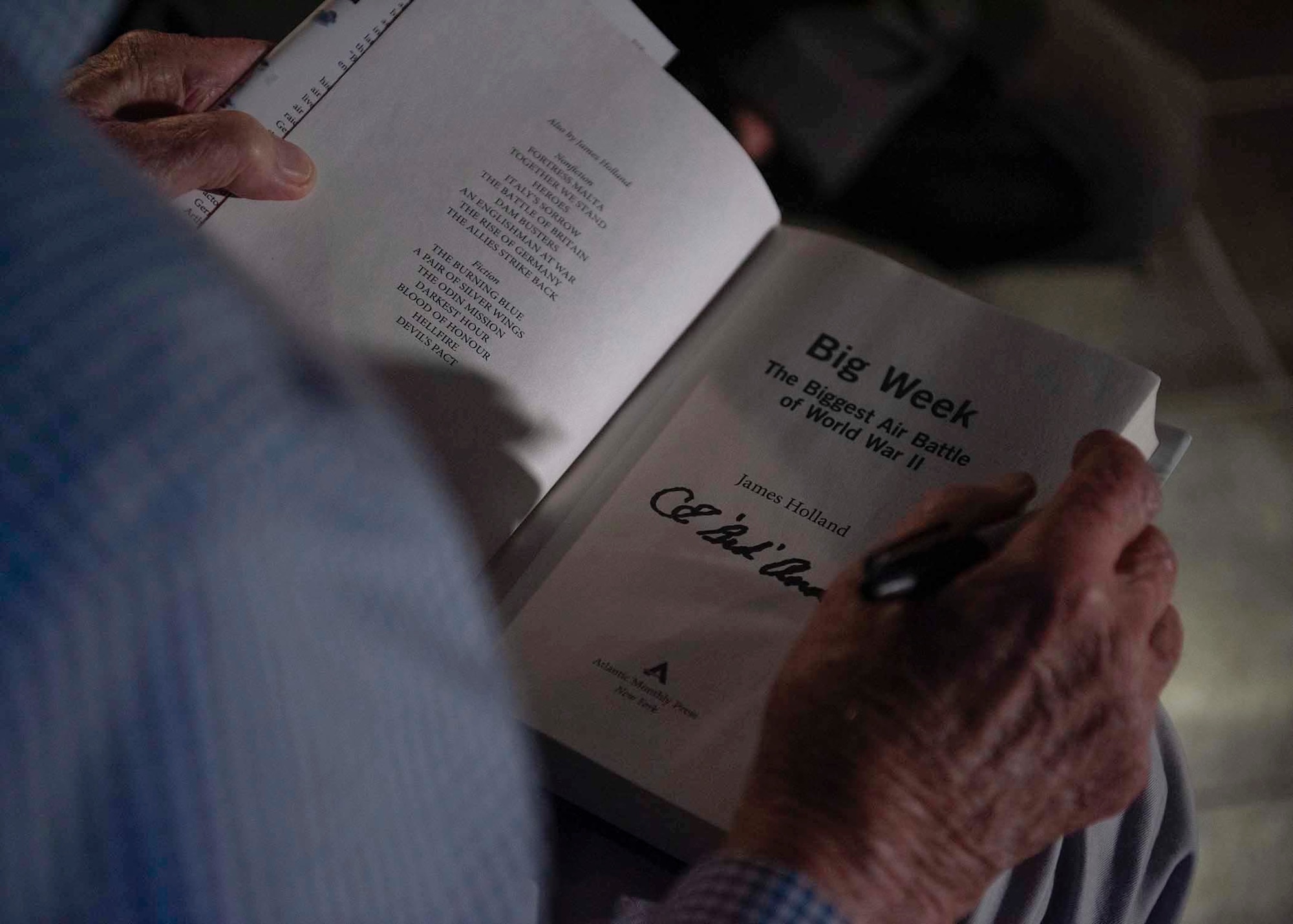 An Army Air Corps retiree signs a book.