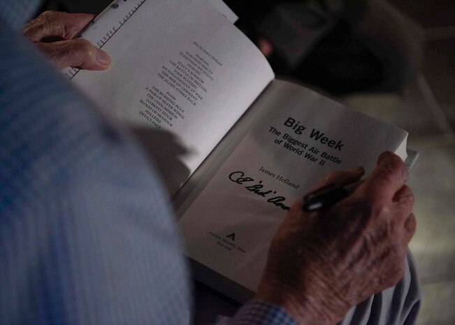 An Army Air Corps retiree signs a book.