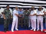 190425-N-ZZ999-001 CHITTAGONG, Bangladesh (April 25, 2019) Rear Admiral Joey Tynch, commander, Logistics Group Western Pacific, left, presents a symbolic key to Bangladesh Navy senior delagates during a ceremony at the Special Warfare Diving and Salvage (SWADS) Headquarters in Chittagong. Five metal patrol boats were handed over to the Bangladesh Navy and a ceremony was held commemorating the exchange of the crafts and celebrating the long-standing partnership between both nations. (Courtesy photo by Lt. Col. Matthew A. Kohler)