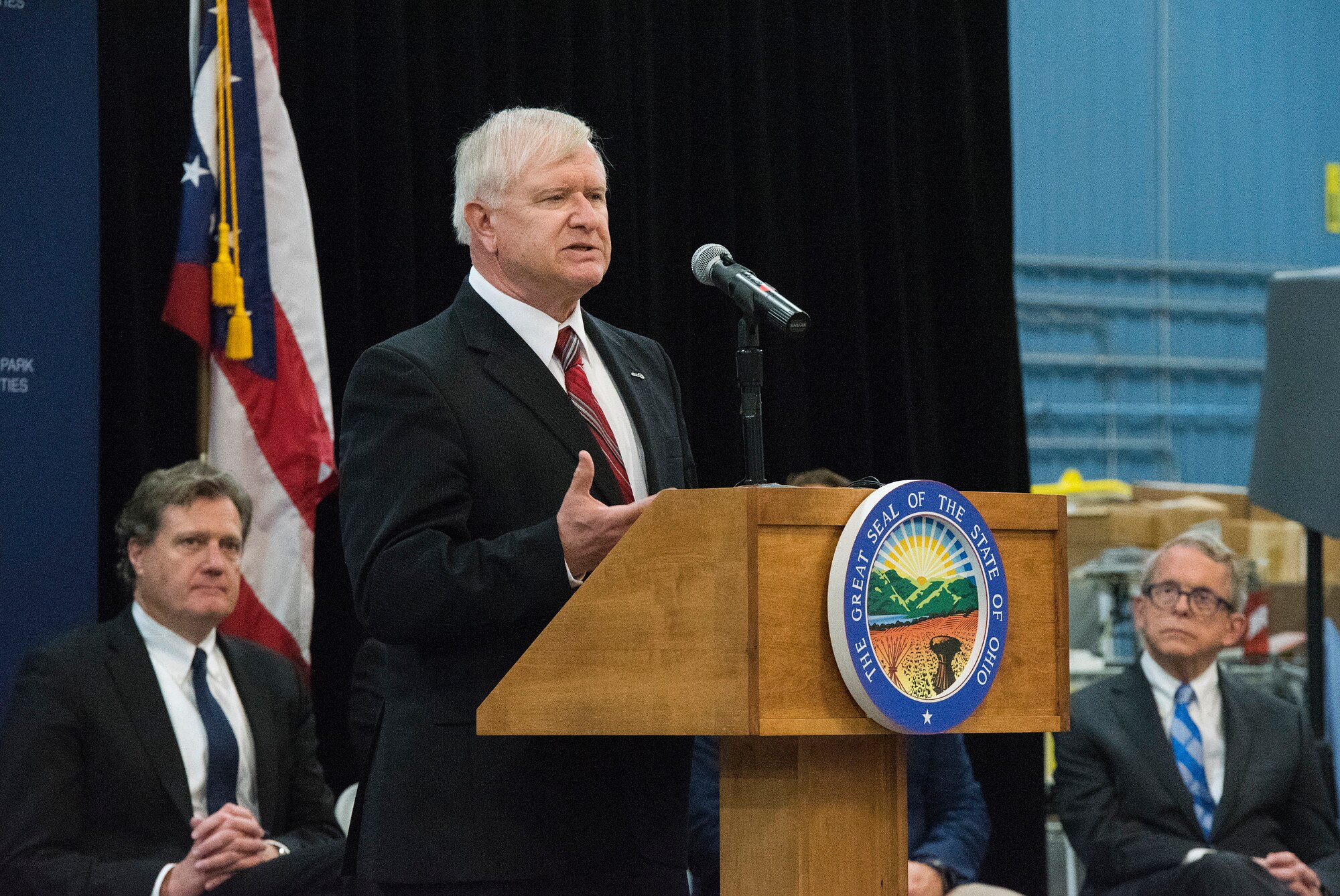 Jack Blackhurst, Air Force Research Laboratory executive director, speaks as U.S. Rep. Mike Turner, left, and Ohio Gov. Mike DeWine, right, listen on April 26, 2019, at the announcement that the Federal Aviation Administration has granted a Certificate of Waiver or Authorization to AFRL for beyond visual line of sight flights of unmanned aerial systems during an event at the Sprinfield-Beckley Municipal Airport. The project took the cooperation of several federal, state, and local agencies to reach the approval stage. (U.S. Air Force photo by R.J. Oriez)