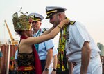 SURABAYA, Indonesia (July 31, 2019) Cmdr. Edward Rosso, commanding officer of the Independence-variant littoral combat ship USS Montgomery (LCS 8), is greeted by traditional Indonesian dancers during a welcoming ceremony hosted by the Indonesian Navy (TNI-AL) in the port of Tanjung Perak after the ship arrived for Cooperation Afloat Readiness and Training (CARAT) Indonesia 2019. CARAT, the U.S. Navy's longest running regional exercise in South and Southeast Asia, strengthens partnerships between regional navies and enhances maritime security cooperation throughout the Indo-Pacific.