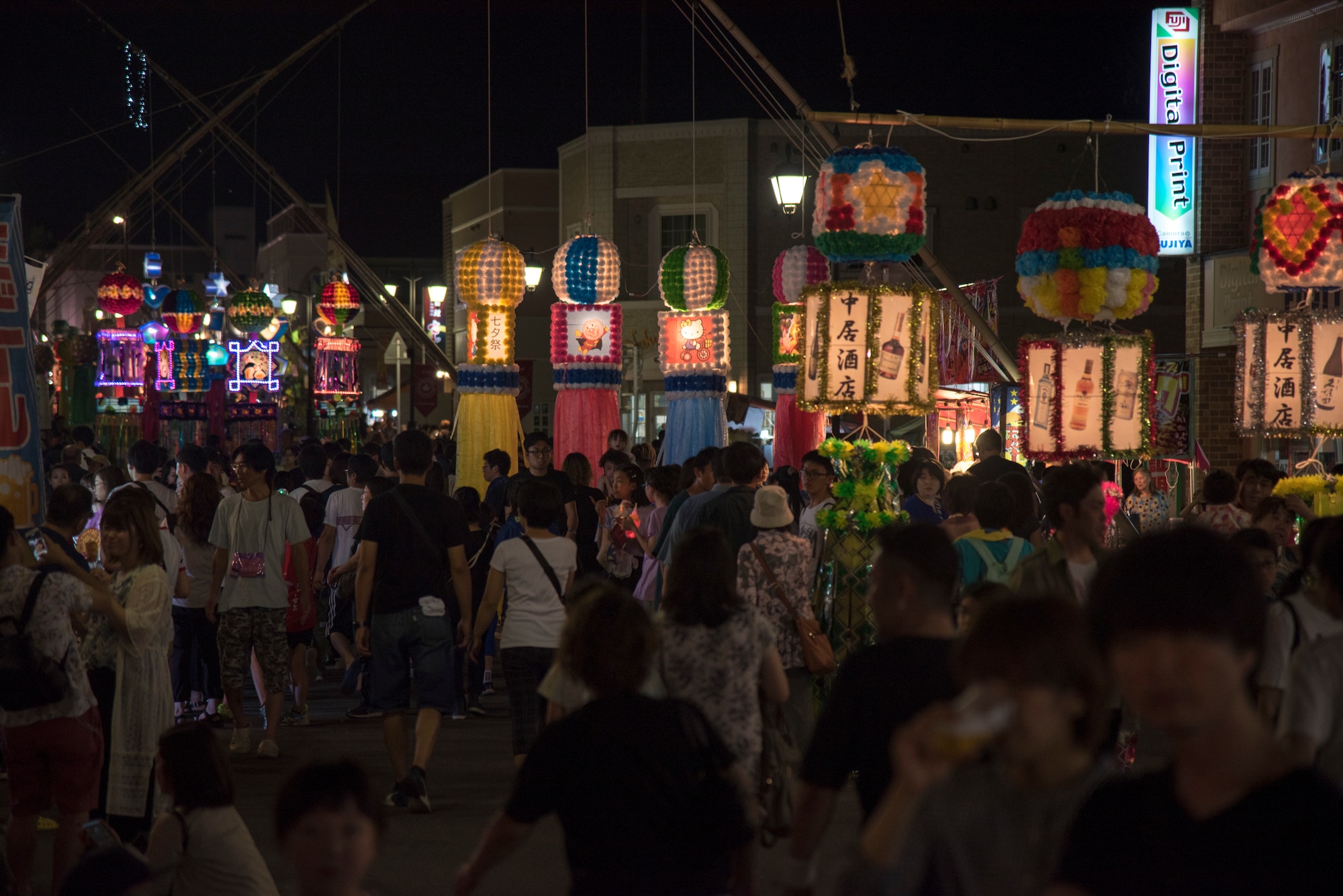 Attendees walk around during the Tanabata Festival in Misawa City, Japan, July 26, 2019. Event attendees enjoyed paper mache decorations, live musical performances, basketball games and a variety of food vendors in addition to socializing and connecting with each other. (U.S. Air Force photo by Branden Yamada)