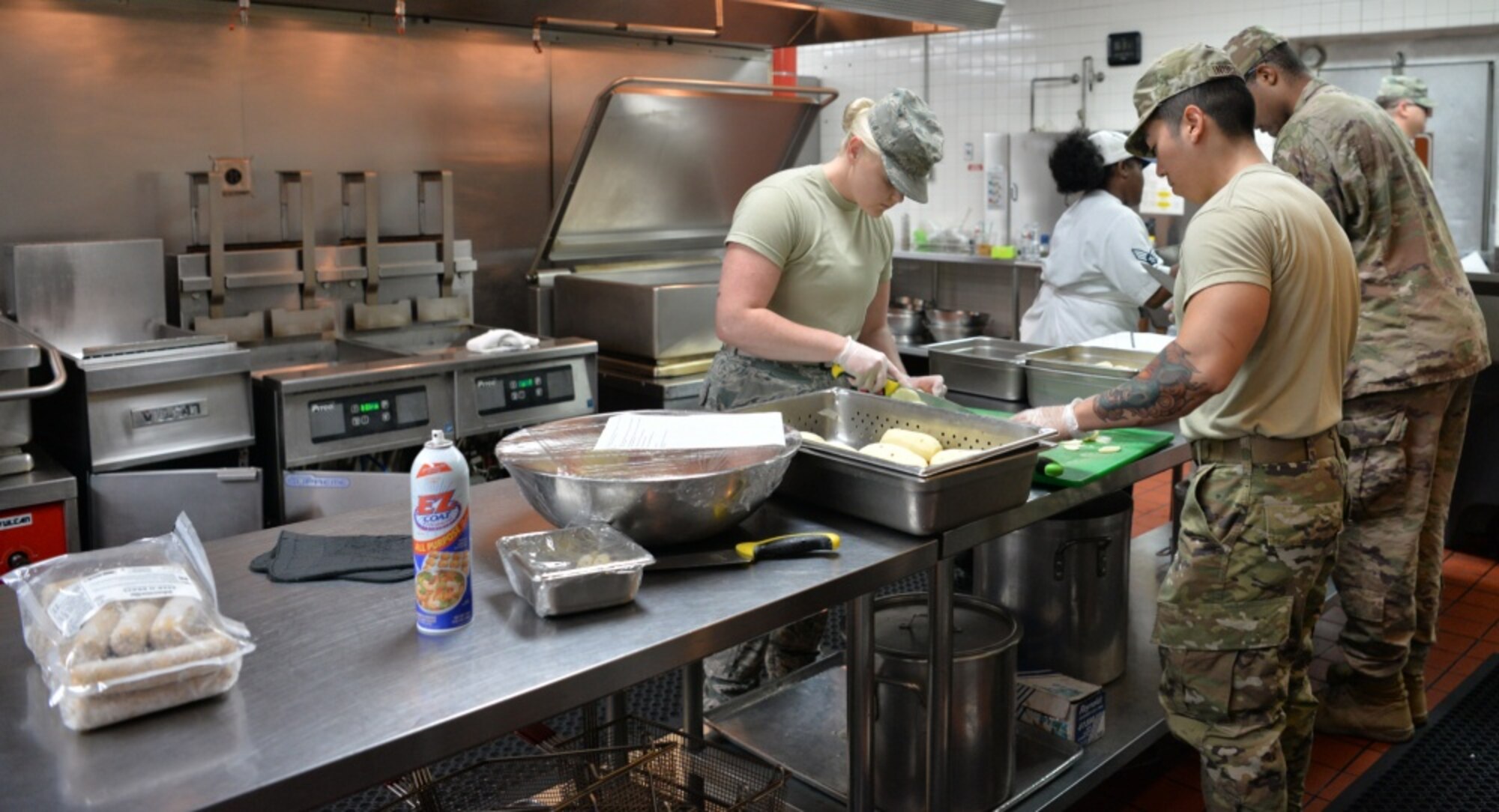 The food service team at the Crosswinds Dining Facility prepares lunch for service members at Nellis Air Force Base, Nevada, July 25, 2019. They work together to ensure new members are properly trained. Augmentees were sent to Nellis to help with the influx of customers during Red Flag and other exercises throughout the year. (U.S. Air Force photo by Tech. Sgt. Bryan Magee)