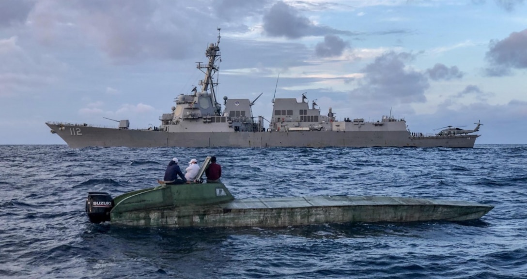 USS Michael Murphy's in the water next to a low profile vessel.