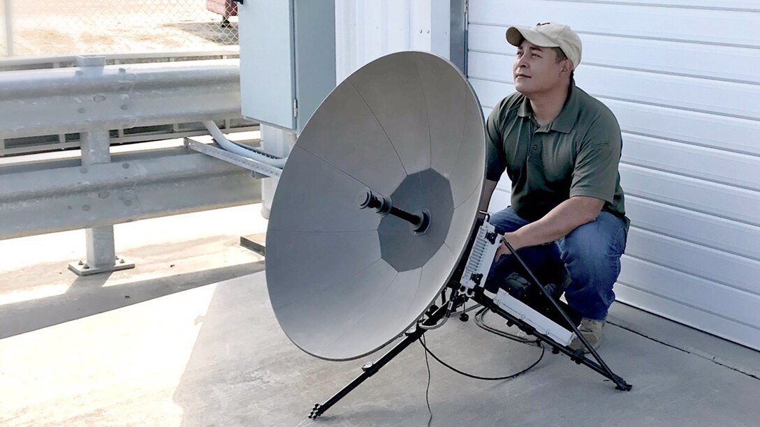 Defense Logistics Agency Contingency Information Technology employee sets up a satellite.