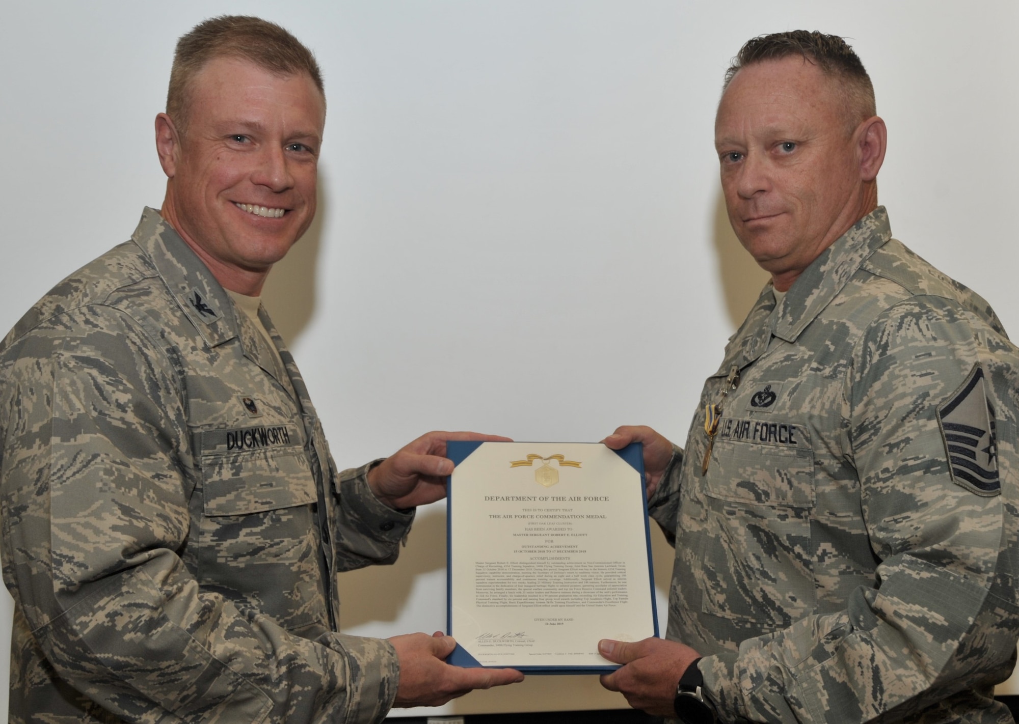 Master Sgt. Robert Elliott, Reserve military training instructor assigned to the 433rd Training Squadron, Joint Base San Antonio-Lackland, Texas, accepts the citation to accompany the award of the Air Force Commendation Medal, presented by 340th Flying Training Group Commander Col. Allen Duckworth during the 433rd’s unit training assembly and enlisted summit held at JBSA-Lackland July 23-25. Duckworth also coined Elliott for his exceptional success in recruiting Reserve MTIs. (U.S. Air Force photo by Debbie Gildea)