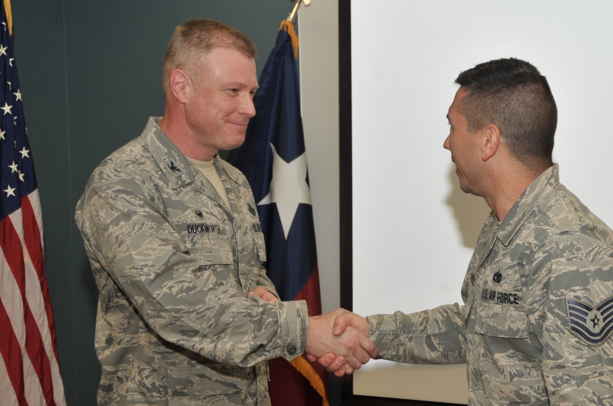 Tech. Sgt. Jason Hernandez, Reserve military training instructor assigned to the 433rd Training Squadron, Joint Base San Antonio-Lackland, Texas, accepts a commander’s coin for exceptional performance from 340th Flying Training Group Commander Col. Allen Duckworth during the 433rd’s unit training assembly and enlisted summit held at JBSA-Lackland July 23-25. Hernandez also accepted an NCO of the quarter award from an earlier period this year. (U.S. Air Force photo by Debbie Gildea)