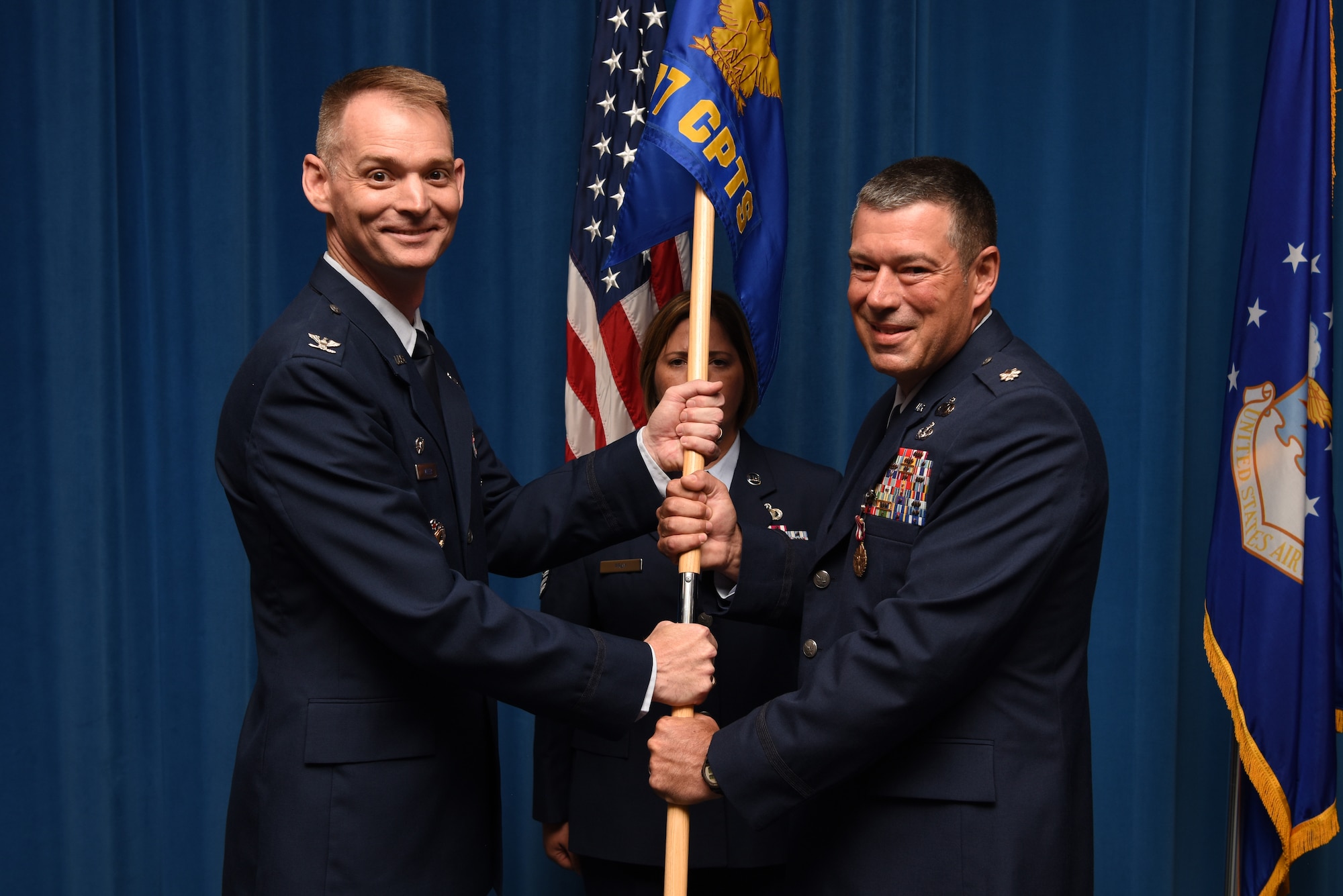 U.S. Air Force Lt. Col. William Beauter (right), outgoing 377th Comptroller Squadron commander, passes the guidon to Col. David Miller, 377th Air Base Wing commander, during a change of command ceremony at Kirtland Air Force Base, N.M., July 31, 2019. Beauter is scheduled to assume command of Reserve Officer Training Corps Det. 510. (U.S. Air Force photo by Senior Airman Eli Chevalier)