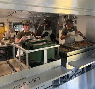 Pfc Victoria Clark, Spec Sorin Tatah, and Pfc Delmar Osorio-Ortiz, assigned to the 642nd Aviation Support Battalion, New York Army National Guard, cook inside the Containerized on July 27th for their annual training at Fort Indian Town Gap, PA as part of the Connelly competition evaluation.