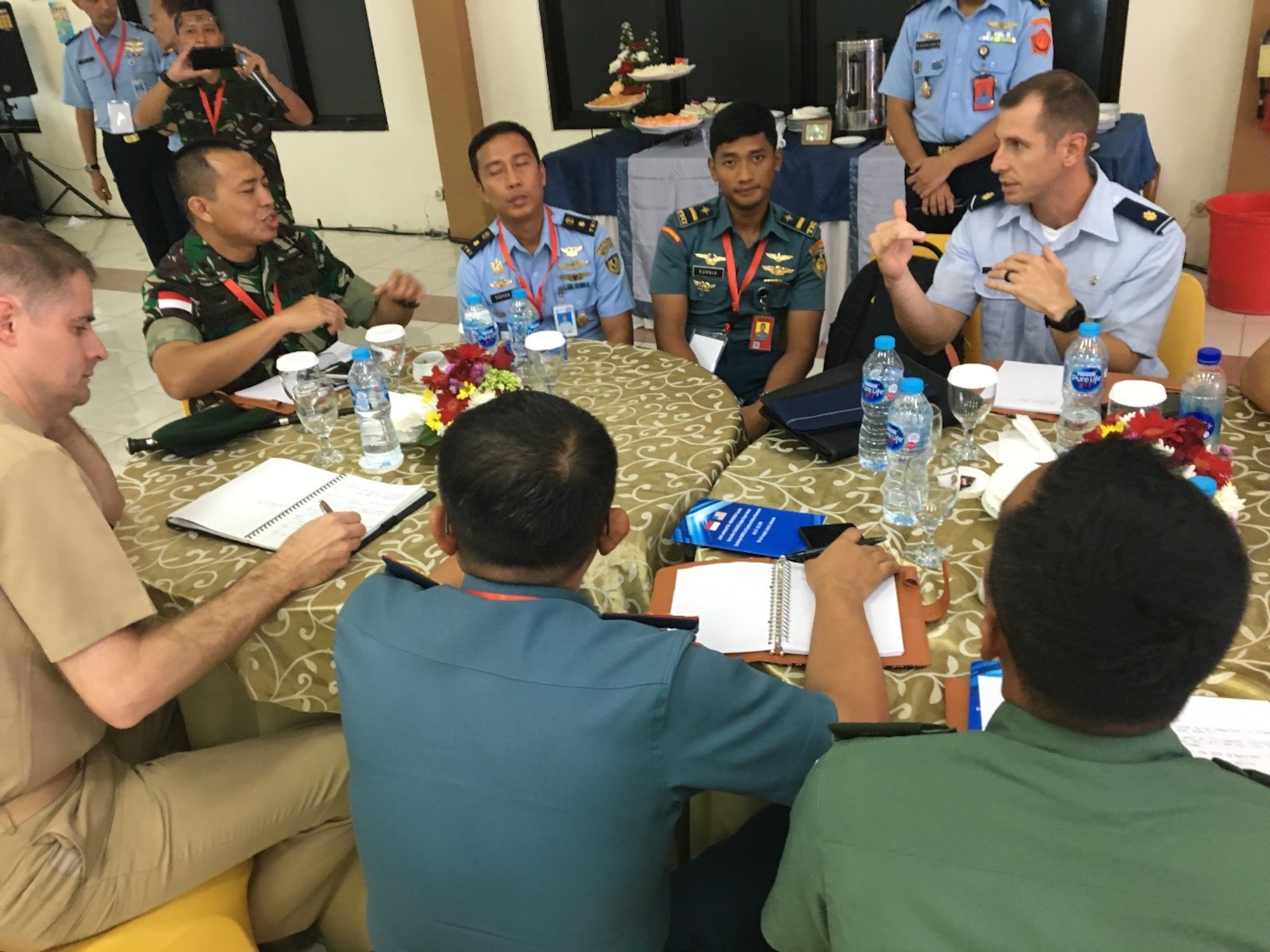 U.S. Navy Dr. (Lt. Cmdr.) Andrew Branham,  Group Surgeon from Marine Aircraft Group 13, , and U.S. Air Force Maj. Brian Johnson, 36th Medical Support Squadron Medical Readiness Flight commander  discusses how to plan and conduct a joint medical operation with their Indonesian National Armed Forces counterparts during a tabletop exercise. (Courtesy Photo)