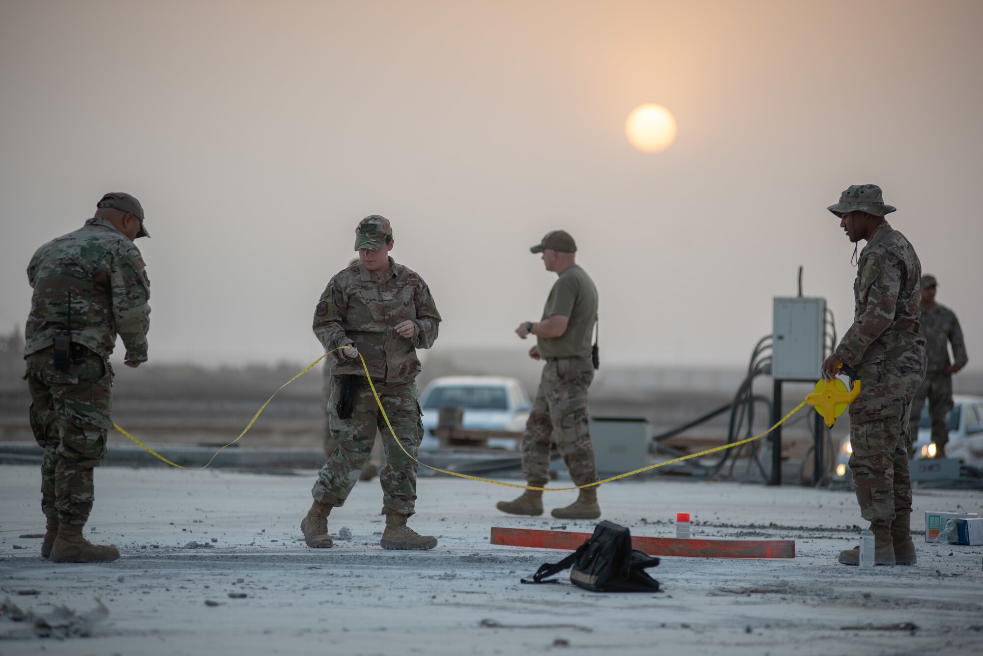 Three 380th Expeditionary Civil Engineer Squadron water and fuels technicians mark damaged areas during a rapid airfield damage repair exercise July 26, 2019, at Al Dhafra Air Base, United Arab Emirates. The concrete was then broken up and removed. (U.S. Air Force photo by Staff Sgt. Chris Thornbury)