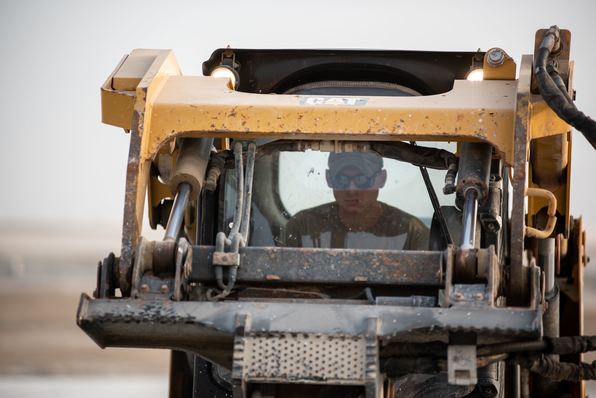 Airman 1st Class Louis Lamorgese, 380th Expeditionary Civil Engineer Squadron heavy equipment operator, uses a compact track loader with a jackhammer attachment to break concrete during a rapid airfield damage repair exercise July 26, 2019, at Al Dhafra Air Base, United Arab Emirates. After breaking the concrete apart, an excavator can remove the debris leaving the hole to be filled with fast-curing concrete. (U.S. Air Force photo by Staff Sgt. Chris Thornbury)