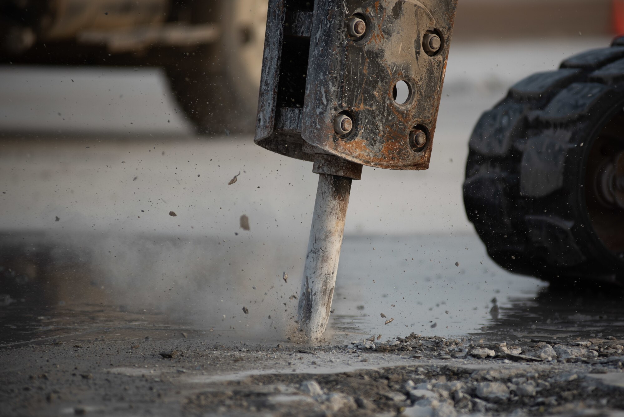 A compact track loader with a jackhammer attachment breaks concrete during a rapid airfield damage repair exercise July 26, 2019, at Al Dhafra Air Base, United Arab Emirates. After breaking the concrete apart, an excavator can remove the debris allowing the hole to be filled with fast-curing concrete. (U.S. Air Force photo by Staff Sgt. Chris Thornbury)