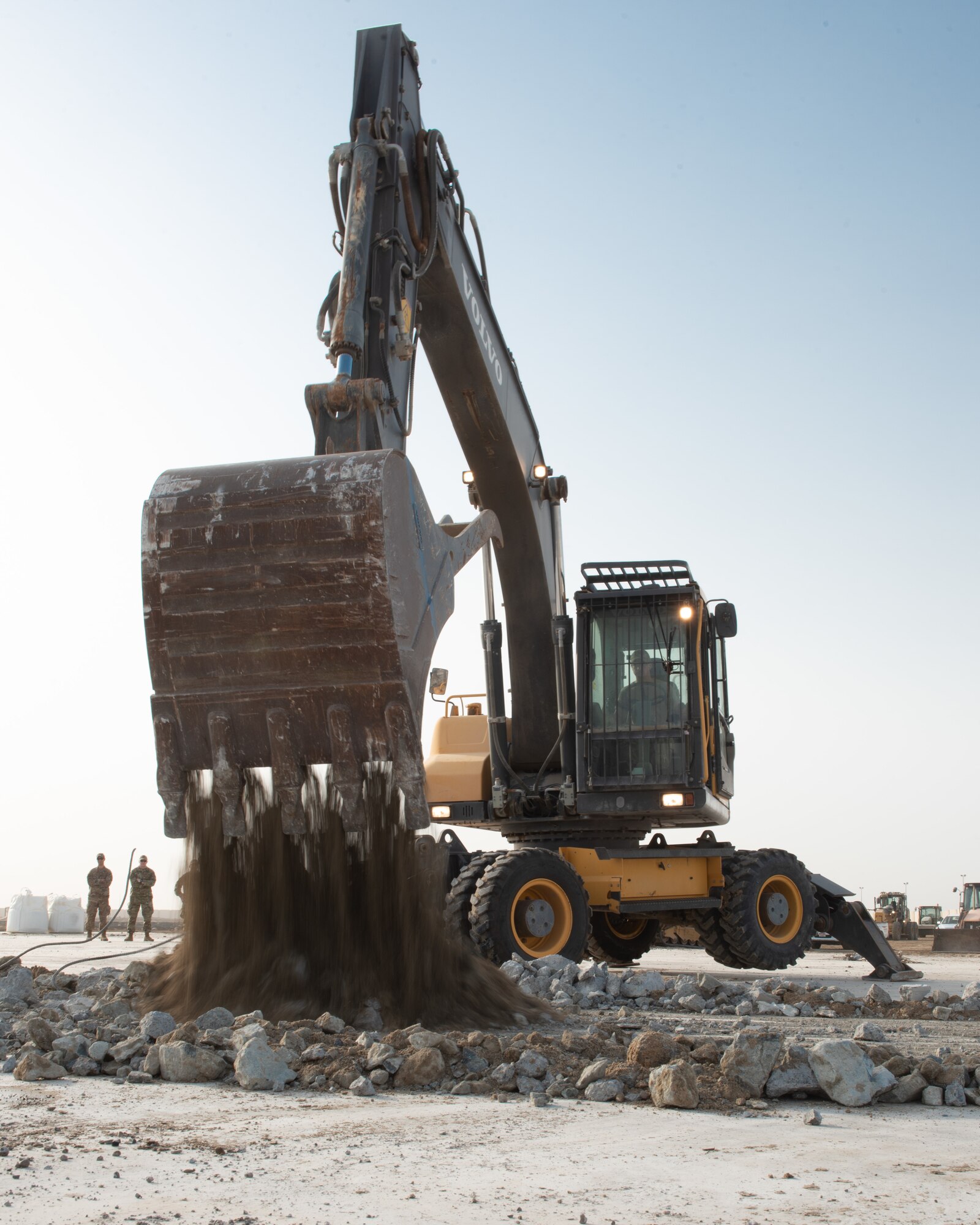 Senior Airman David Smith, 380th Expeditionary Civil Engineer Squadron heavy machine operator, operates an excavator to collect and lift concrete during a rapid airfield damage repair exercise July 26, 2019, at Al Dhafra Air Base, United Arab Emirates. Removing the concrete allows the team to replace the damaged area with new fast-curing concrete to get the airfield operational within hours. (U.S. Air Force photo by Staff Sgt. Chris Thornbury)