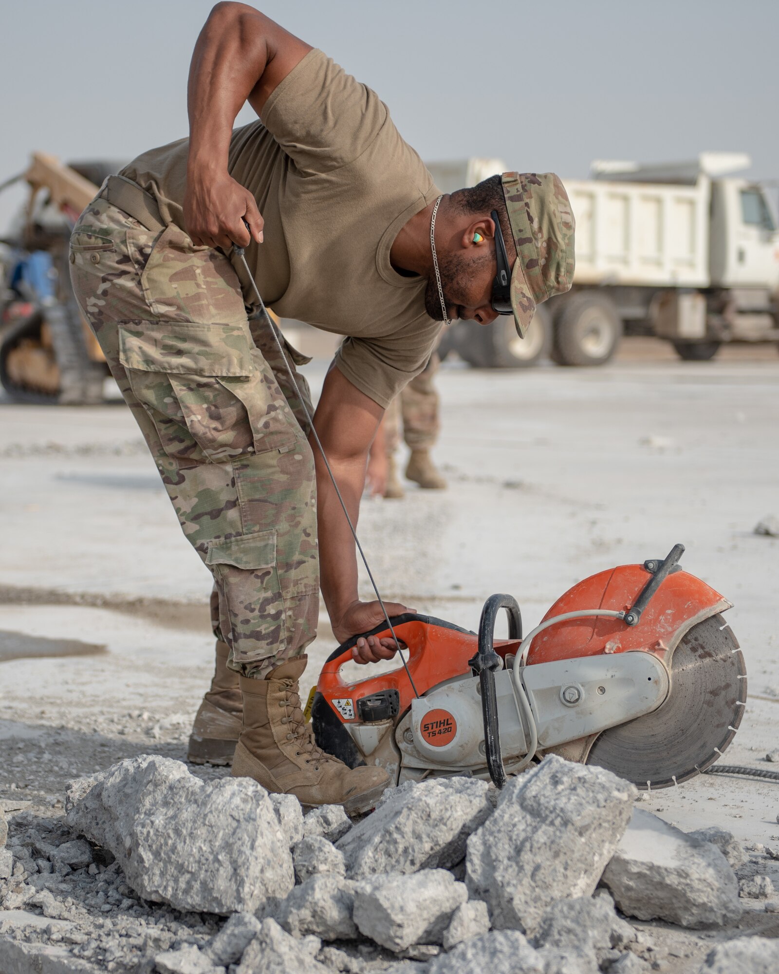 Senior Airman Brandon McLendon, 380th Expeditionary Civil Engineer Squadron heavy machine operator, pull starts a cut-off machine during a rapid airfield damage repair exercise July 26, 2019, at Al Dhafra Air Base, United Arab Emirates. The saw is used to cut rebar to create more room for an excavator to remove damaged concrete. (U.S. Air Force photo by Staff Sgt. Chris Thornbury)