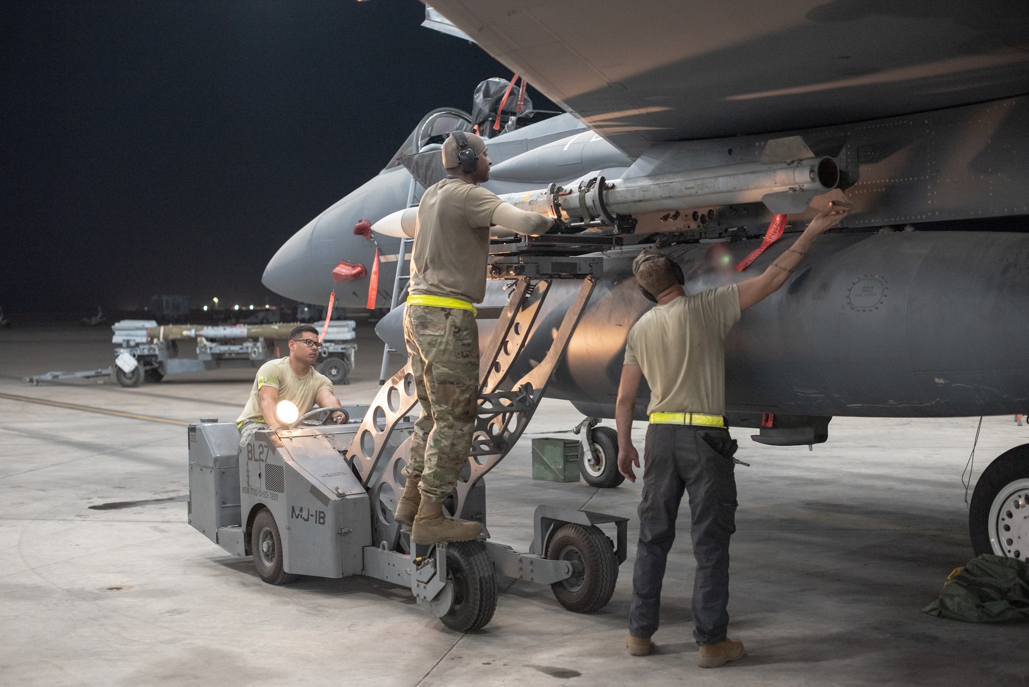 An F-15E Strike Eagle weapons load crew team attaches an AIM-120D to a pylon July 15, 2019, at Al Dhafra Air Base, United Arab Emirates. The AIM-120D is the latest Advanced Medium-Range Air-to-Air missile (AMRAAM) and features improved navigation, kinematics, lethality and hardware and software updates to enhance its electronic protection capabilities against more capable threats. (U.S. Air Force photo by Staff Sgt. Chris Thornbury)