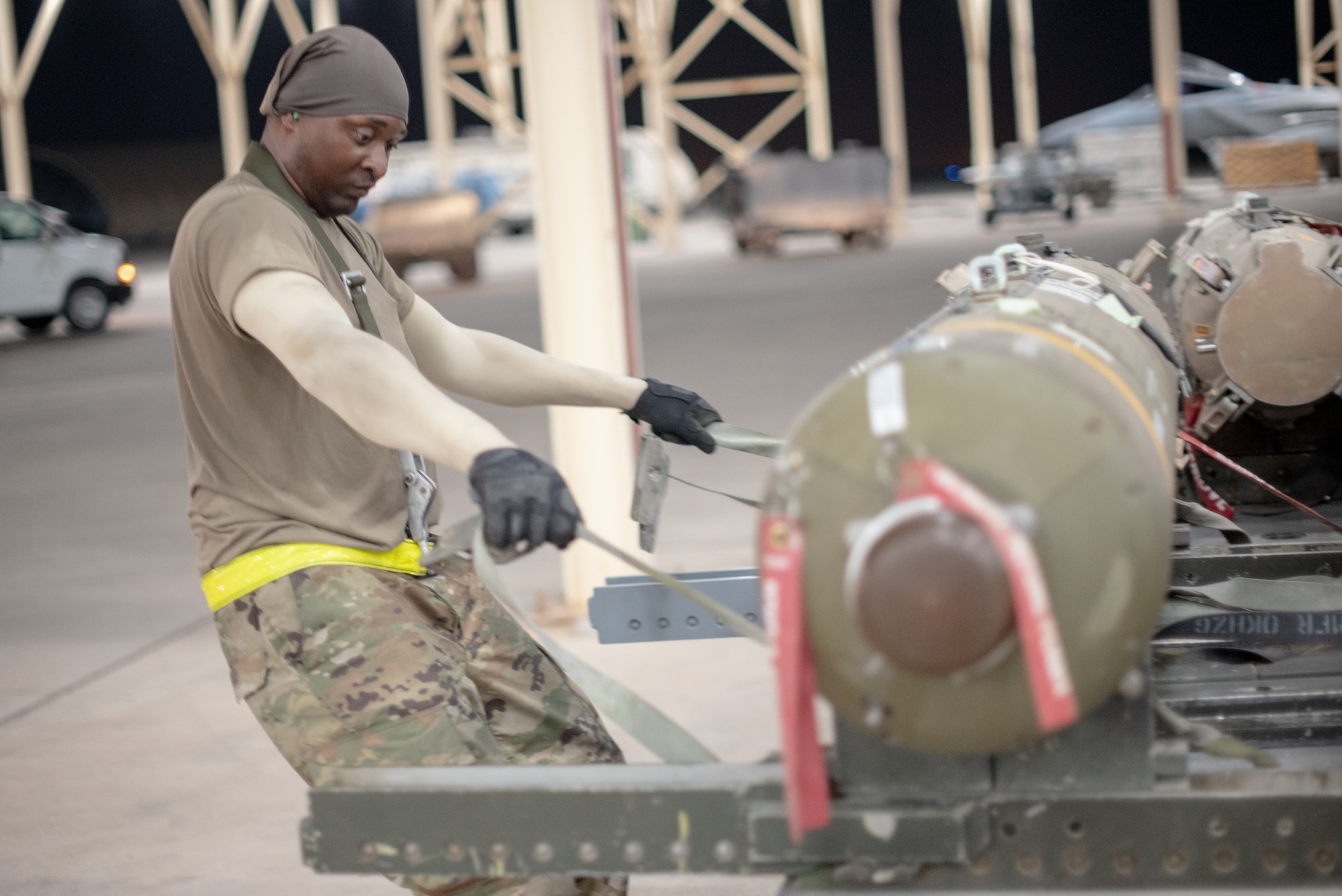 Staff Sgt. Kiefer May, 380th Expeditionary Aircraft Maintenance Squadron weapons load crew team chief, pulls a munition away from a trailer July 15, 2019, at Al Dhafra Air Base, United Arab Emirates. Weapons load crews work 24/7 operations to support loading and configuring various munitions for the F-35A Lightning II, F-15E Strike Eagle and F-15C Eagle jets at ADAB. (U.S. Air Force photo by Staff Sgt. Chris Thornbury)