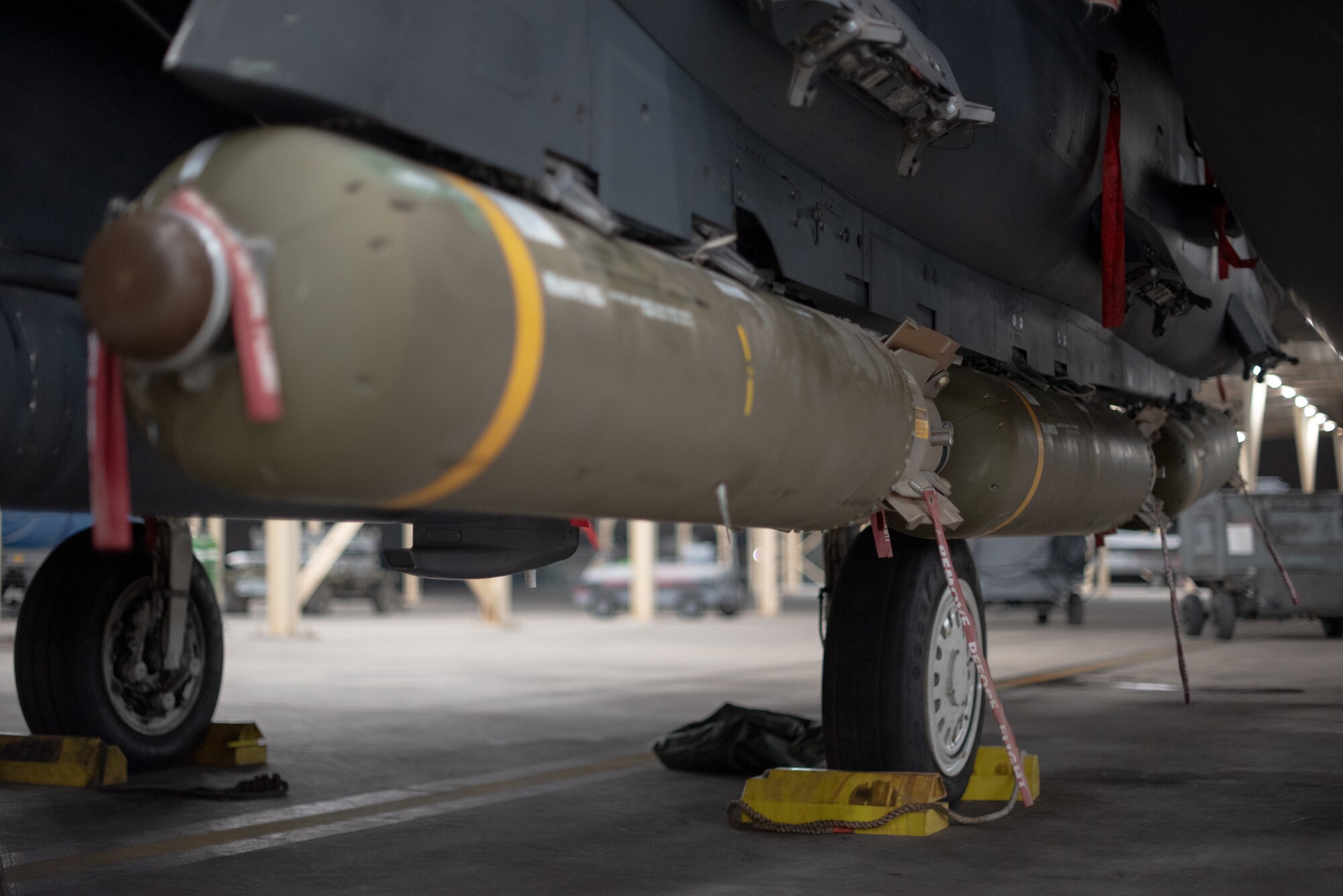 Munitions sit below an F-15E Strike Eagle July 15, 2019, at Al Dhafra Air Base, United Arab Emirates. Diverse weapons loads on the F-15E arm the jet with a multitude of capabilities while flying in support of maritime combat air patrol missions in the Arabian Gulf. (U.S. Air Force photo by Staff Sgt. Chris Thornbury)