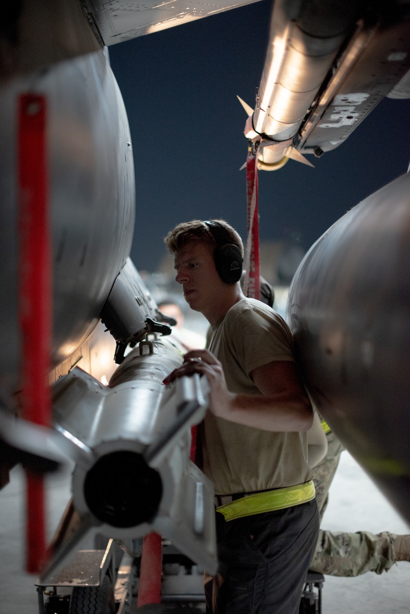 Senior Airman Sean Logan, 380th Expeditionary Aircraft Maintenance Squadron weapons load crew team member, helps attach a GBU-12 to an F-15E Strike Eagle July 15, 2019, at Al Dhafra Air Base, United Arab Emirates. The F-15E is a dual-role fighter designed to perform air-to-air and air-to-ground missions and currently supporting surface combat air patrol operations in the Arabian Gulf. (U.S. Air Force photo by Staff Sgt. Chris Thornbury)