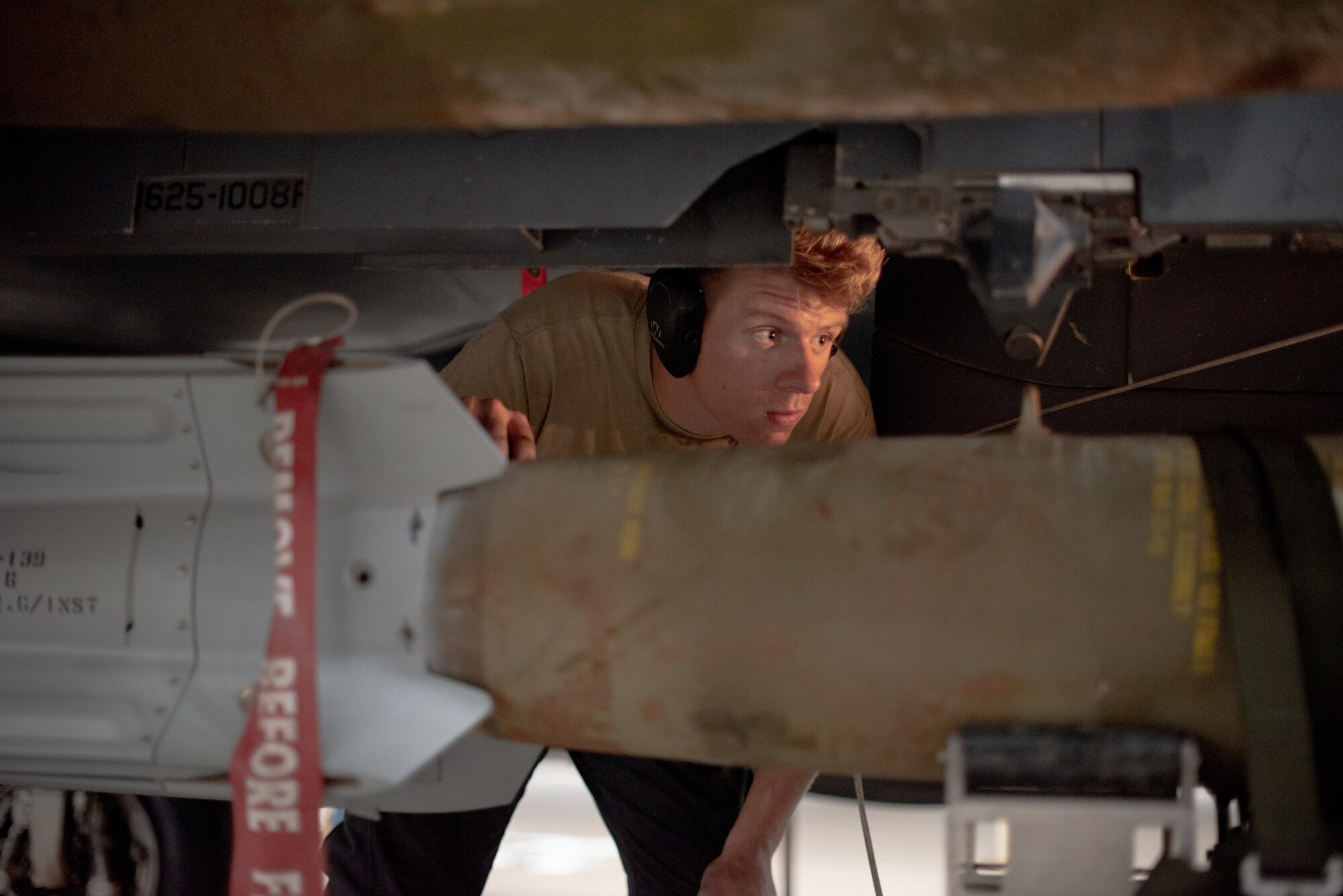 Senior Airman Sean Logan, 380th Expeditionary Aircraft Maintenance Squadron weapons load crew team member, watches a lift driver move a munition under an F-15E Strike Eagle July 15, 2019, at Al Dhafra Air Base, United Arab Emirates. The F-15E has the capability to carry any air-to-surface weapon in the Air Force inventory. (U.S. Air Force photo by Staff Sgt. Chris Thornbury)