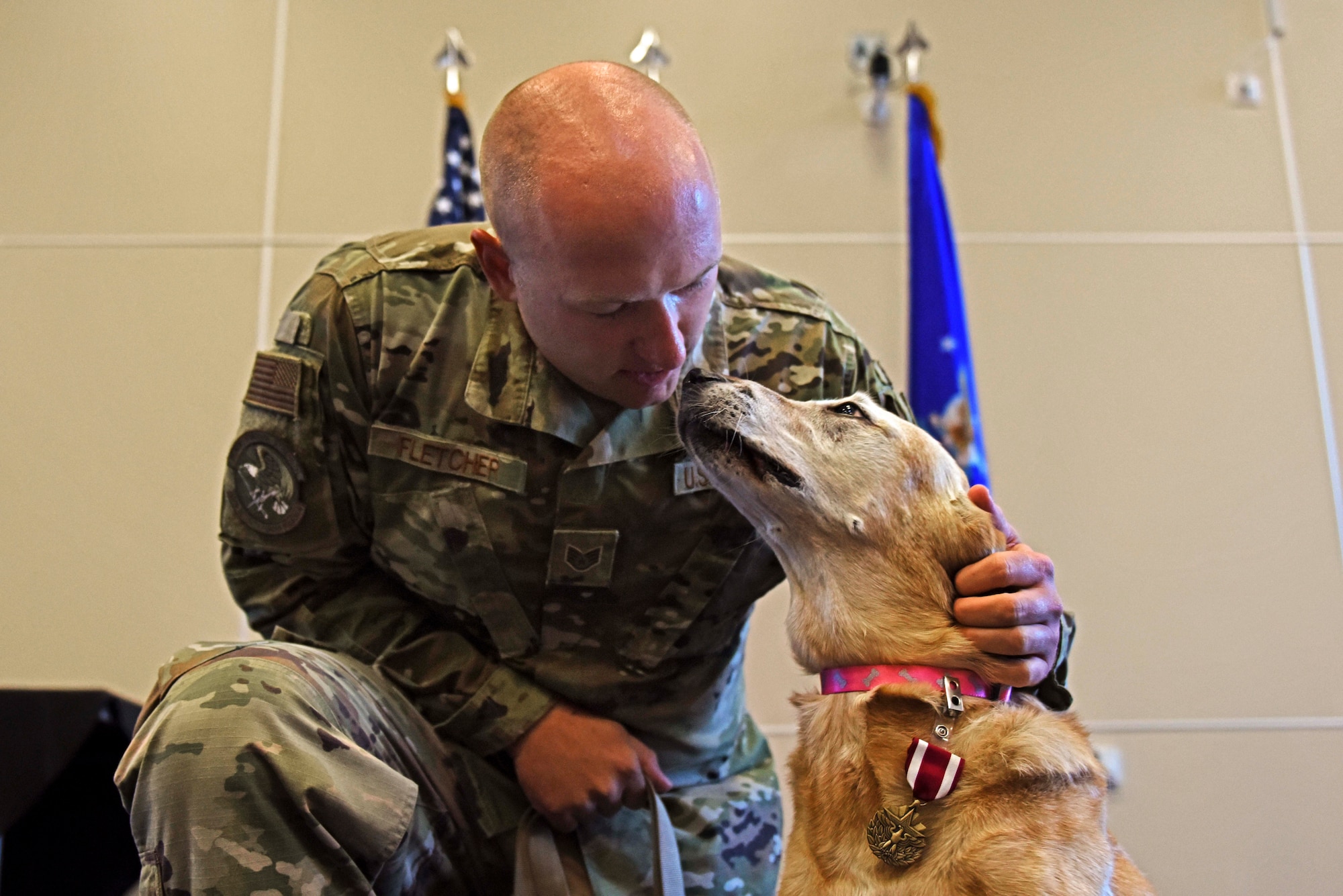 U.S. Air Force Staff Sgt. Nicholas Fletcher, 39th Security Forces Squadron military working dog trainer, pets Autumn, his MWD, during the latter’s retirement ceremony at Incirlik Air Base, Turkey, July 29, 2019. Working dogs are usually offered for adoption upon their retirement from military service, and undergo transition period with their handlers in preparation for life as a pet. (U.S. Air Force photo by Staff Sgt. Joshua Magbanua)