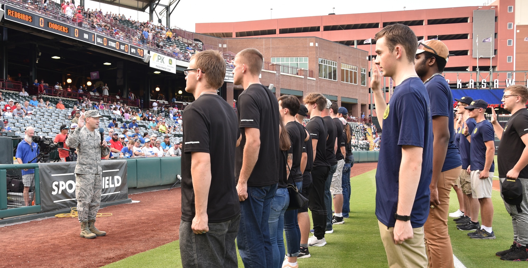 Col. Paul Filcek, 72nd Air Base Wing commander, administers the oath of enlistment during the Oklahoma City Dodgers game July 26 during Military Appreciation Night. (U.S. Air Force photo/Amy Schiess)