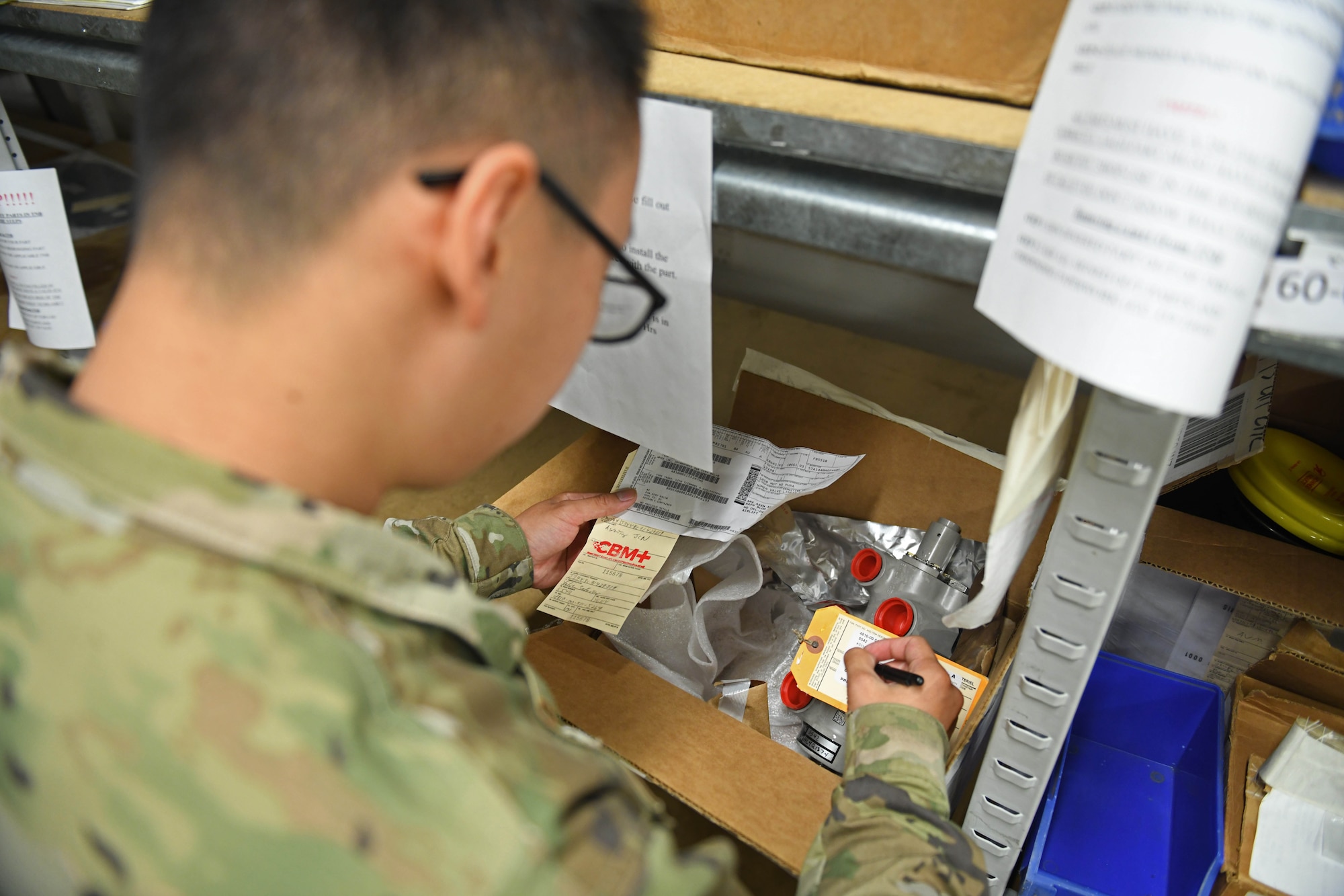 Senior Airman Grant Vang, 100th Logistics Readiness Squadron decentralized maintenance support journeyman, fills out a label for maintenance supplies at RAF Mildenhall, England, July 31, 2019. The 100th DMS supports five different squadrons on RAF Mildenhall encompassing three different major commands. (U.S. Air Force photo by Senior Airman Luke Milano)