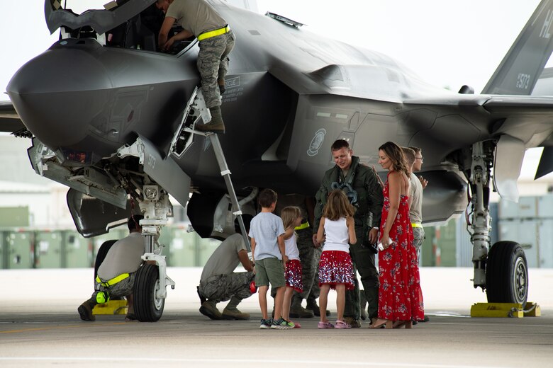 An F-35A Lightning II pilot with the 421st Fighter Squadron greets his family plane-side he returns from a deployment to Hill Air Force Base, Utah, July 31, 2019. The 421st Fighter Squadron participated in several combat exercises with allied and partner nations while deployed to Europe. (U.S. Air Force photo by R. Nial Bradshaw)