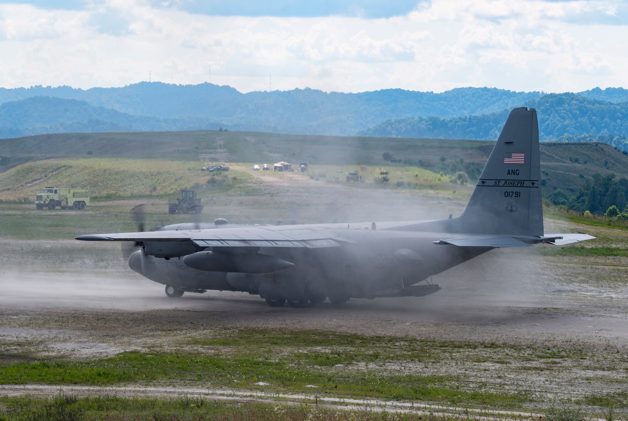 A C-130H Hercules lands on a dirt runway
