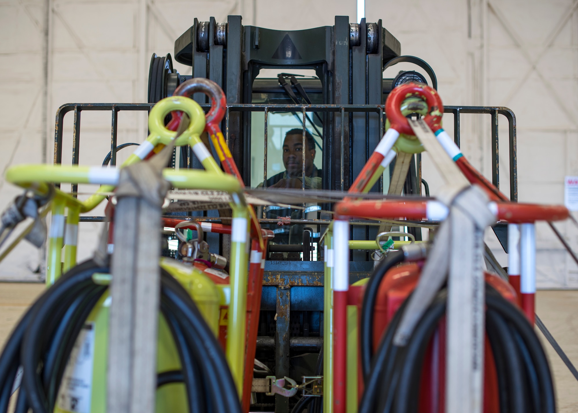 U.S. Air Force Senior Airman Jevon Butler, 92nd Logistics Readiness Squadron air transportation journeyman, transports cargo with a forklift during a Cargo Deployment Function exercise at Fairchild Air Force Base, Washington, July 24, 2019. It is essential to mission success for Airmen from each moving piece of the CDF line to exercise their crucial role in the event of a mass deployment to meet warfighter needs. (U.S. Air Force photo by Airman 1st Class Whitney Laine)