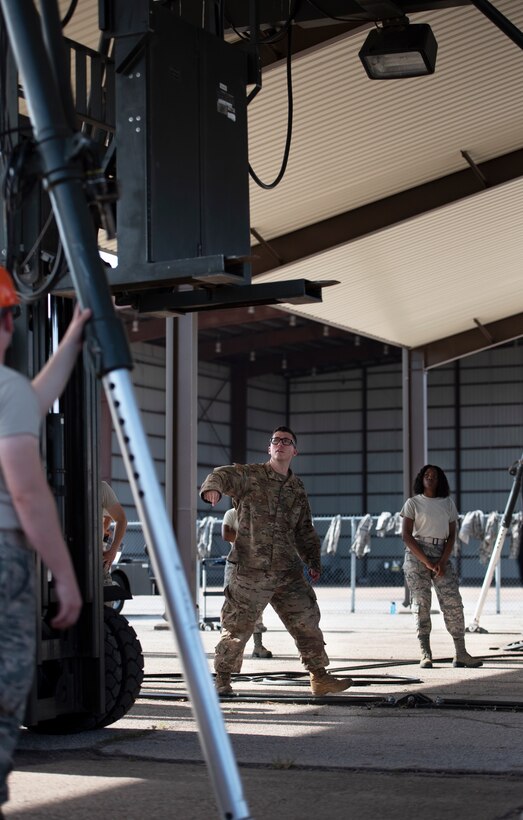 A 363rd Training Squadron munitions apprentice course instructor, center, guides another instructor as they work to build a munitions assembly conveyor at Sheppard Air Force Base, Texas, August 1, 2019. A MAC is used for convenience when a worksite may not have the right environment to set up a munitions shop. The MAC is used to create an assembly line anywhere if need be. (U.S. Air Force photo by Air Force photo by Airman 1st Class Pedro Tenorio)