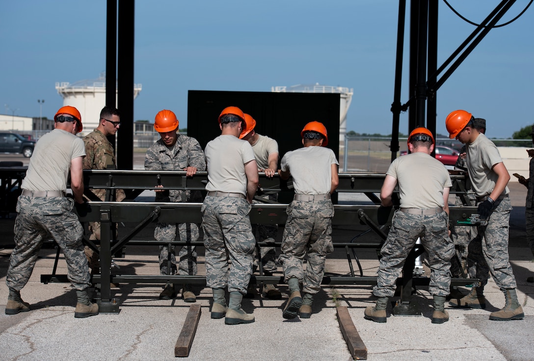 363rd Training Squadron munitions apprentice course students move a munitions assembly conveyor at Sheppard Air Force Base, Texas, August 1, 2019. The MAC can be assembled anywhere and is used in deployments to create an assembly line to build bombs anywhere if need be. This is only one part of the MAC and will be attached to other pieces for a longer conveyor. (U.S. Air Force photo by Air Force photo by Airman 1st Class Pedro Tenorio)